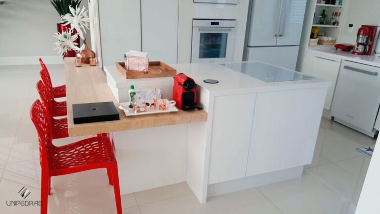 Cozinha com ilha em quartzo branco, estilo americano, bancada de refeições em travertino (3, cadeiras vermelhas, cantinho café, quartzo branco Mármore Romano Bruto | Execução Unip